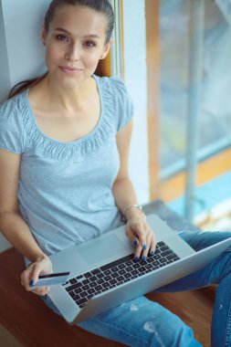 Evde bir dizüstü bilgisayar kullanan genç güzel kadın. Genç güzel kadın.