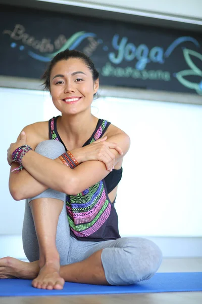 Portrait of smiling yoga woman sitting at yoga mat after workout at yoga studio. Yoga. Woman. — Stock Photo, Image