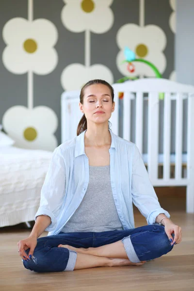 Young woman doing yoga at home in the lotus position. Young woman doing yoga. — Stock Photo, Image