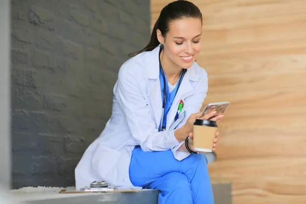 Een jonge vrouwelijke dokter die bij je telefoon zit. Vrouwelijke artsen. — Stockfoto