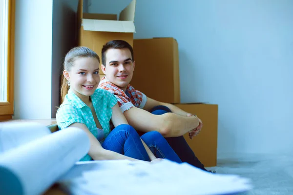 Paar zieht im Haus auf dem Fußboden sitzend ein. Paar — Stockfoto