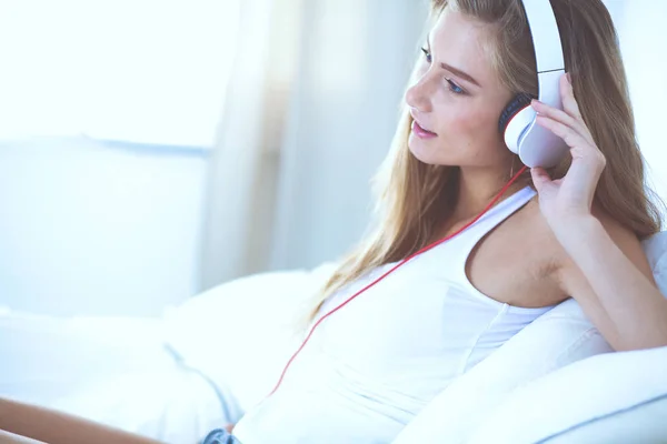 Retrato de una hermosa mujer en la mañana escuchando música sentada en la cama en casa. Retrato de mujer hermosa —  Fotos de Stock