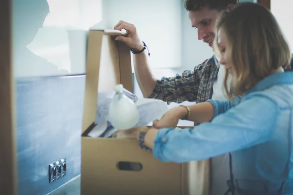 Pareja joven que lleva la caja de cartón grande en el nuevo hogar.Mudanza de la casa. Pareja joven —  Fotos de Stock