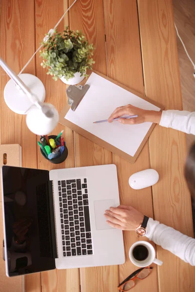 Masada oturan genç bir kadın..