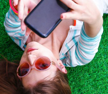 güzel ve genç birbayan yeşil çim yalan onu telefonla selfie yapma