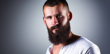 Ayakta, gri arka plan üzerinde izole yakışıklı adam portresi