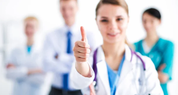Médica atraente na frente do grupo médico mostrando ok — Fotografia de Stock