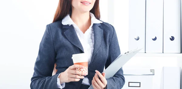 Attraktive junge Geschäftsfrau steht mit Ordner am Schreibtisch im Büro — Stockfoto