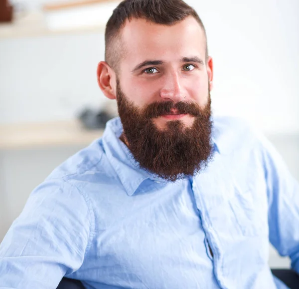 Young businessman sitting on chair in office — Stock Photo, Image