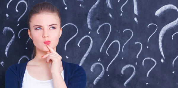 Young girl with question mark on a gray background — Stock Photo, Image