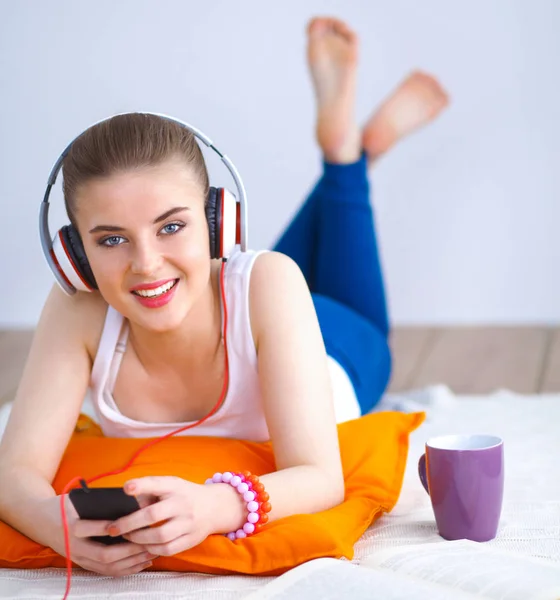 Mujer joven tumbada en el suelo y escuchando música —  Fotos de Stock