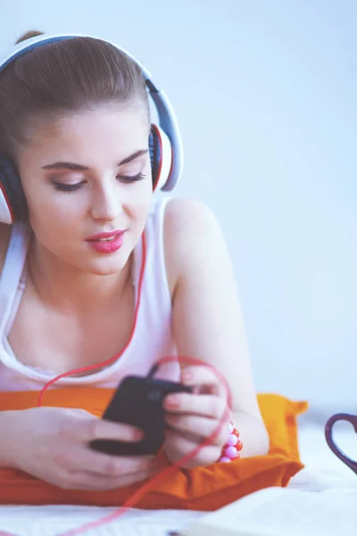 Young woman lying on floor and listen to music — Stock Photo, Image