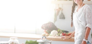 Mutfakta masanın yanında duran genç bir kadın.