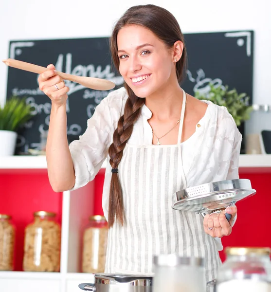 Mujer cocinera en cocina con cuchara de madera —  Fotos de Stock