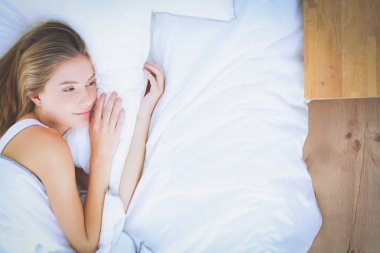 Genç kadın ve çalar saat evde yatak odasında uyuyor. Genç uyuyan kadın.