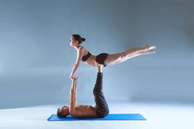 Genç çift Acro yoga mat Studio birlikte uygulamak. Acroyoga. Çift yoga. Ortak yoga.