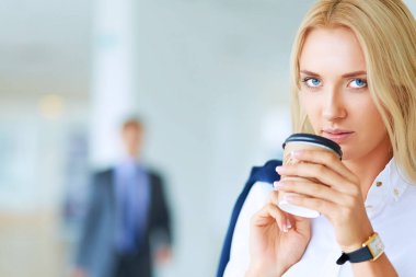 Yound kadın ayakta ofisindeki kahve içmek