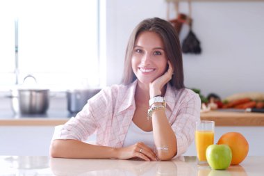 Mutfakta masada oturan genç bir kadın.