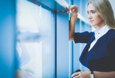 Yound kadın ayakta ofisindeki kahve içmek