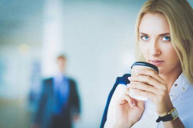 Yound kadın ayakta ofisindeki kahve içmek