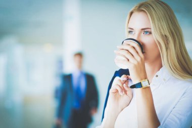 Yound kadın ayakta ofisindeki kahve içmek