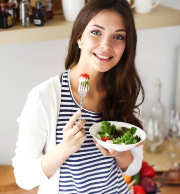 Genç bayan mutfakta masanın yanında oturuyor.