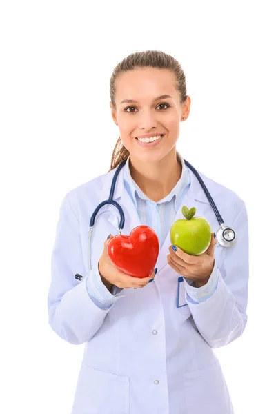 Красивая улыбающаяся женщина-доктор с красным сердцем и зеленым яблоком. Женщина-врач — стоковое фото