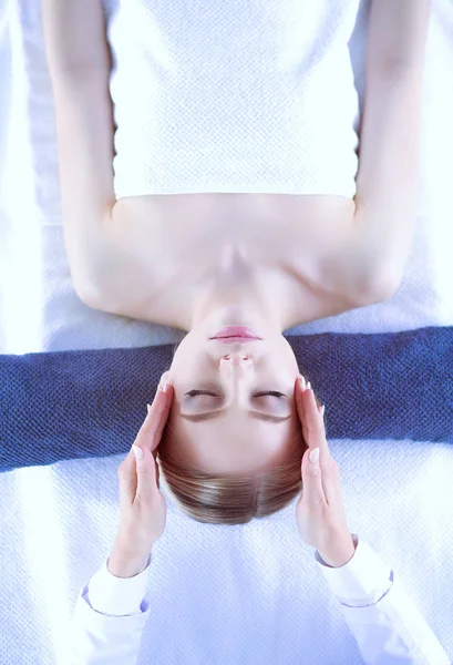 Jeune femme allongée sur une table de massage, relaxante les yeux fermés. Femme. Salon de spa — Photo