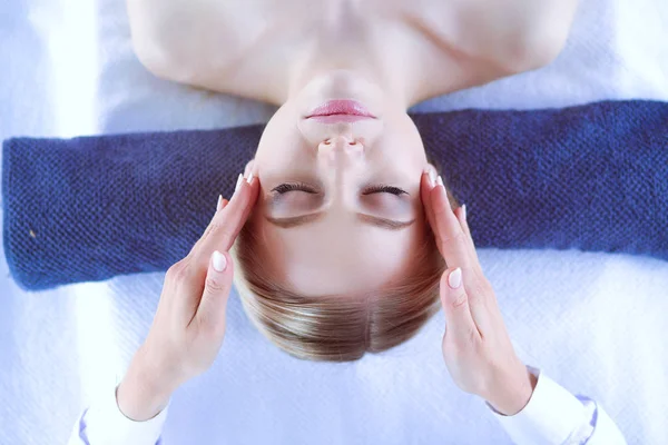 Jonge vrouw liggend op een massagetafel, ontspannend met gesloten ogen. Vrouw. Kuuroord — Stockfoto