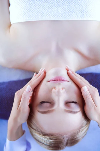 Jeune femme allongée sur une table de massage, relaxante les yeux fermés. Femme. Salon de spa — Photo