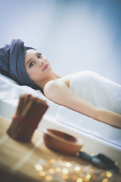 Jonge vrouw liggend op een massagetafel, ontspannend met gesloten ogen. Vrouw. Kuuroord — Stockfoto