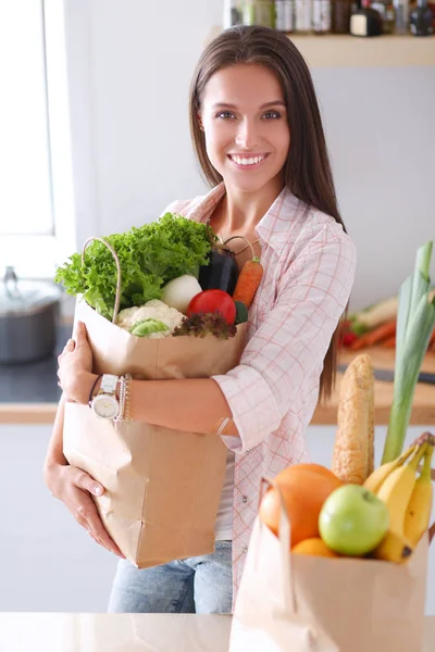 Jovem segurando supermercado saco de compras com legumes — Fotografia de Stock