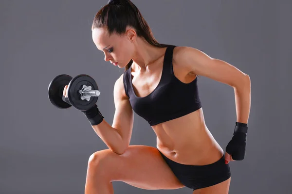 Athletic woman pumping up muscules with dumbbells — Stock Photo, Image