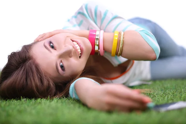 Lachende jonge vrouw liggend op het gras en het maken van een selfie — Stockfoto