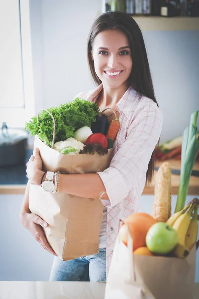 Νεαρή γυναίκα κρατώντας τσάντα ψώνια με λαχανικά — Φωτογραφία Αρχείου