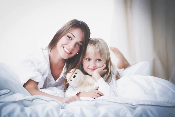 Mutlu sevgi dolu aile. Anne ve kızı çocuk kızı yatakta oynarken — Stok fotoğraf