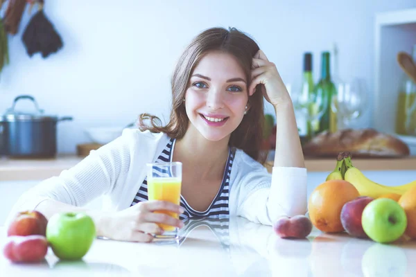 Young woman standing near desk in the kitchen — Stock Photo, Image