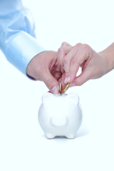 A hand hold a coin into the pig coin bank money box isolated white background — Stock Photo, Image