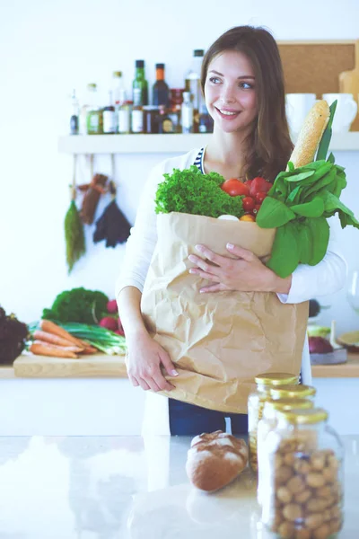 Junge Frau mit Einkaufstasche mit Gemüse und Karte — Stockfoto