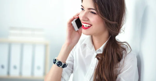 Uśmiechnięta bizneswoman rozmawiająca przez telefon w biurze — Zdjęcie stockowe