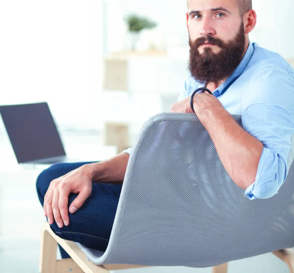 Jungunternehmer sitzt auf Stuhl im Büro — Stockfoto