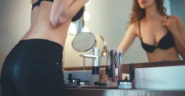 Fiatal nő keresi magát a tükörben, a fürdőszoba — Stock Fotó