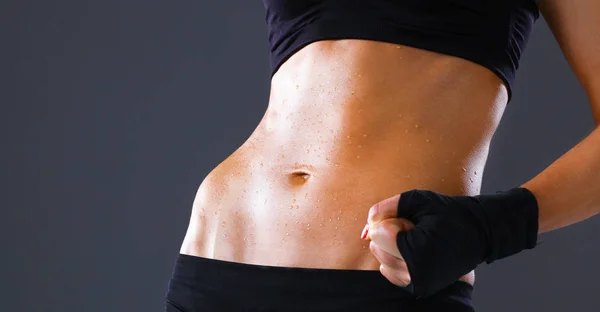 Musclé jeune femme debout sur fond gris — Photo