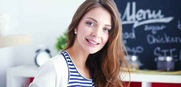 Giovane donna in piedi vicino alla scrivania in cucina — Foto Stock