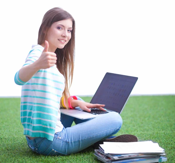 Jeune femme avec ordinateur portable assis sur l'herbe verte — Photo