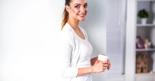 Atrakcyjna młoda bizneswoman stojąca przy ścianie w biurze — Zdjęcie stockowe