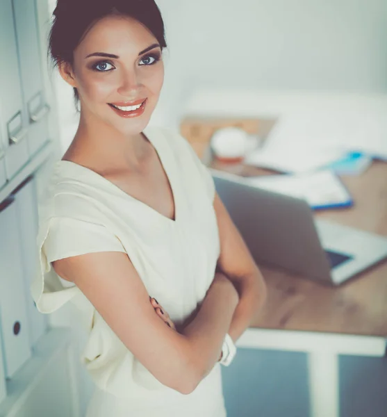 Attrayant femme d'affaires debout près du mur dans le bureau — Photo