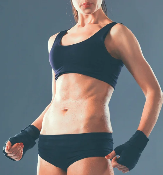 Muscular jovem mulher de pé sobre fundo cinza — Fotografia de Stock