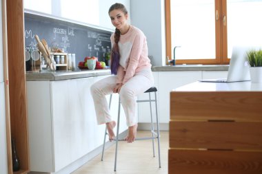 Mutfakta masada oturan genç kadın.