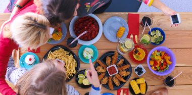 Birlikte yemek yiyen bir grup insanın üst düzey görüntüsü.